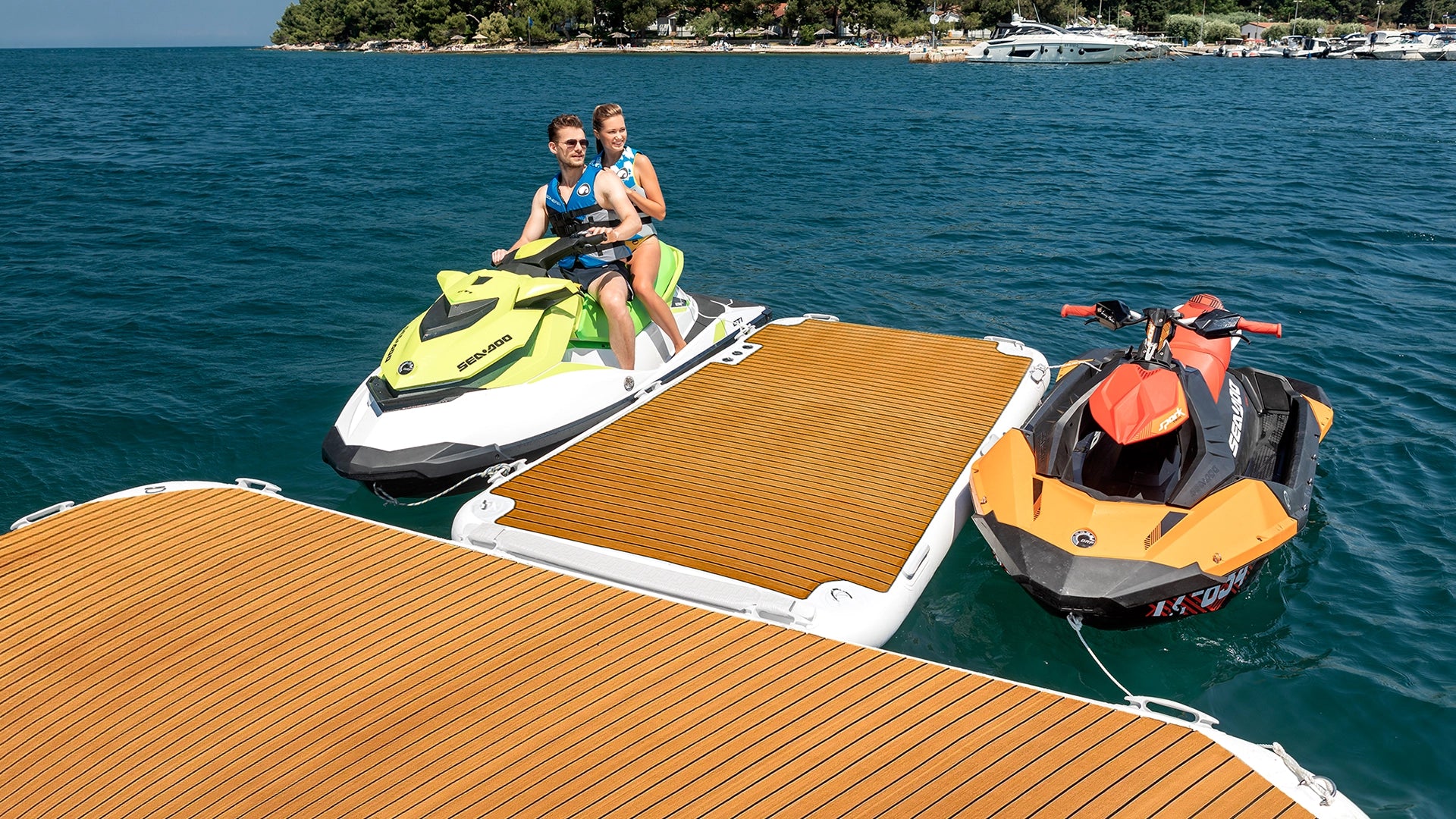 Two jet skis are parked on either side of the Yachtbeach Jet Ski Dock on the water.