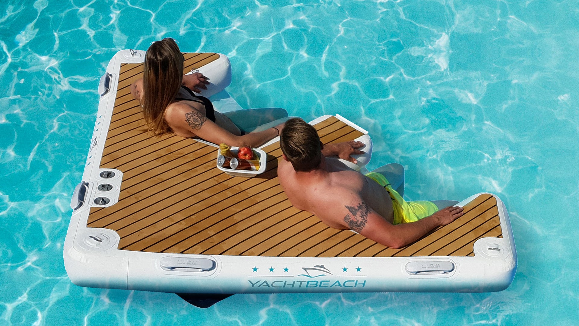 Two people sitting on the Yacht Beach Multi Dock on the water.