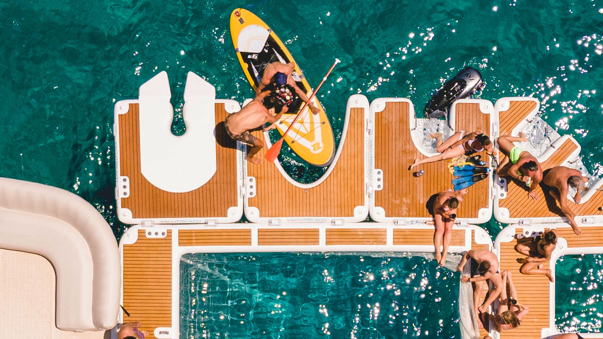 The Yacht Beach Jet Ski Single Version is fixed to other platforms, and people are sitting on them in the water.